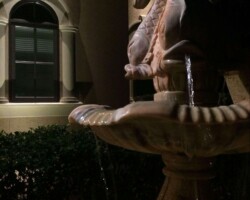 Nighttime garden fountain feature with lighting, surrounded by lush plants and elegant architectural backdrop in Bluffton. Outdoor fountain with lighting enhances nighttime garden ambiance and adds artistic charm for Bluffton home.