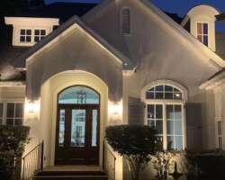 Warm outdoor lights accentuate architectural features while illuminating the entryway and landscaping for this home in Bluffton, SC. Elegant exterior lighting in Bluffton enhances the beauty and security of this home during nighttime.