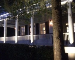 Enhance your Beaufort lowcountry home's curb appeal with stylish outdoor lighting fixtures and warm LED illumination. Night outdoor lighting in Beaufort, SC lowcountry, highlighting a porch with white columns and warm lighting.