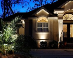 Enhanced curb appeal and security in the Hilton Head coastal region with professional outdoor lighting design and installation. Beautifully illuminating a luxurious Hilton Head area home exterior at night with landscape lighting.
