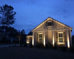 Beautifully lit Bluffton home exterior showcasing landscape lighting to boost curb appeal and security. Elegant outdoor lighting enhances the aesthetic appeal of this Bluffton residence during nighttime.
